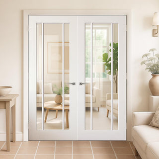 Image: White French doors leading to a living room with beige walls and furniture.