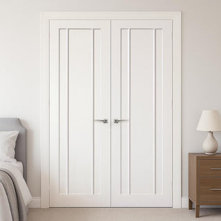 Image: White interior doors in a bedroom setting with a bed and nightstand.