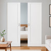 Modern interior with white sliding doors, wooden floor, and minimal decor.