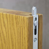Image of a chrome flush bolt on an oak door